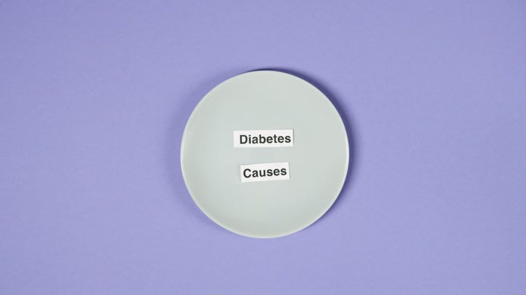 A conceptual photo of a white plate with diabetes causes text on a purple background.